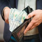 Unlock Strategies for Boosting Social Security Benefits When Rejoining the Workforce Wallet filled with hundred dollar bills being held