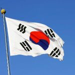 South Korea’s Battle for Democracy Amidst Martial Law Controversy South Korean flag waving against clear blue sky.