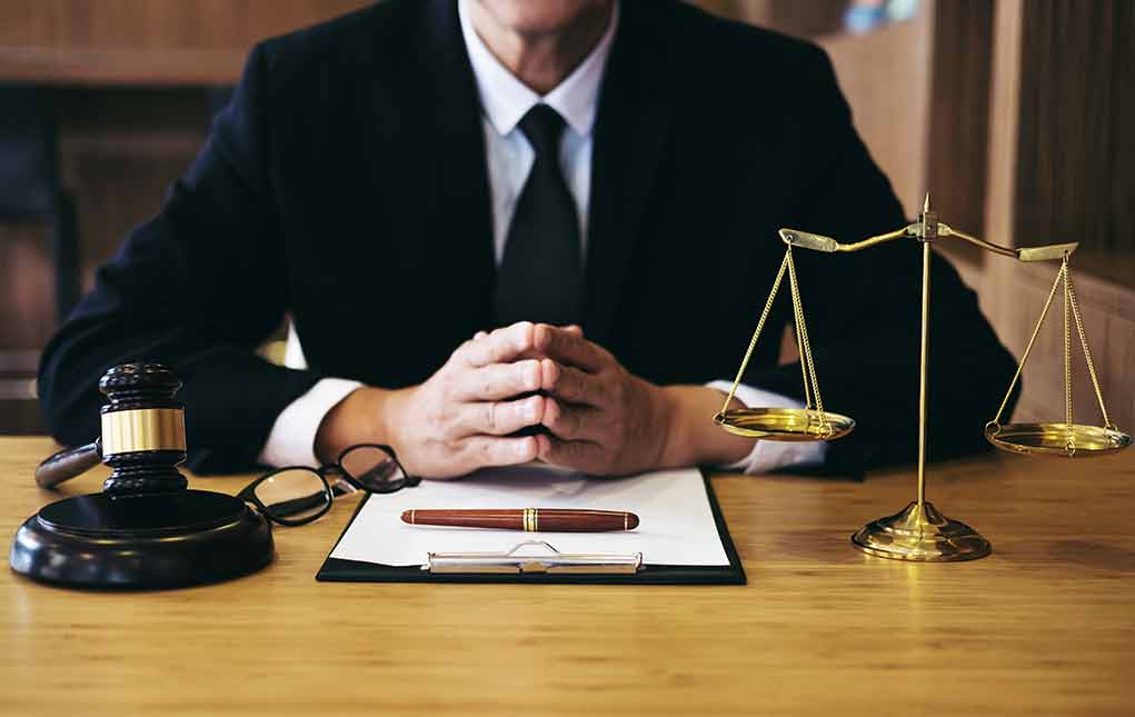 1092414422 featured image Person in suit with gavel and scales of justice