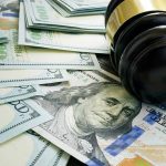 Bessent’s Nomination Sparks Federal Minimum Wage Debate: What’s at Stake? Gavel and hundred dollar bills on table.