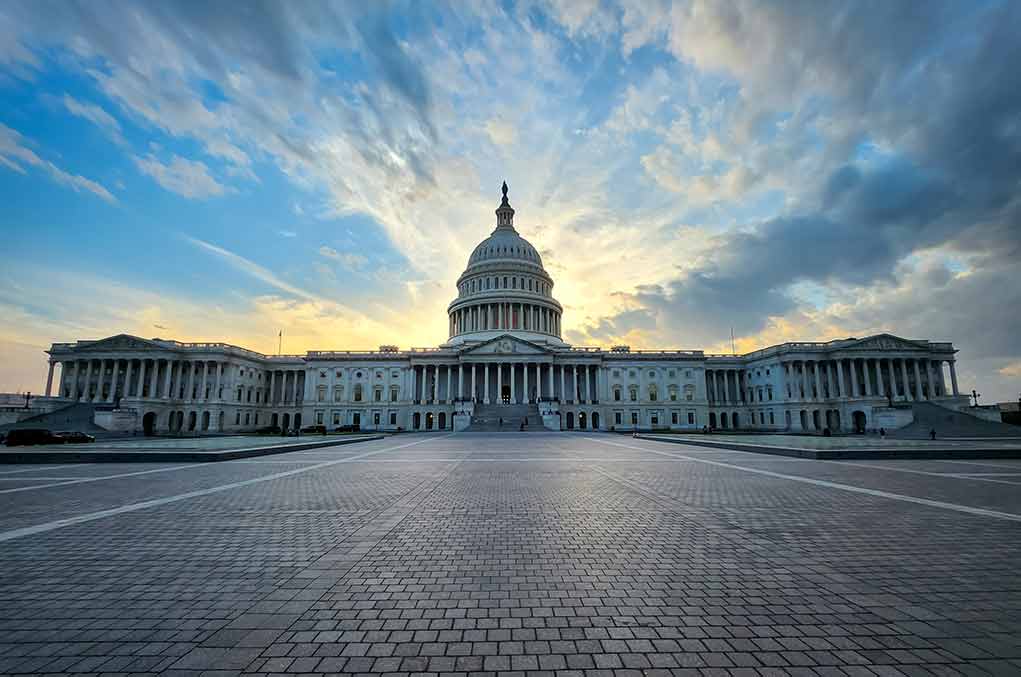 Capitol building under dramatic sky at sunset or sunrise