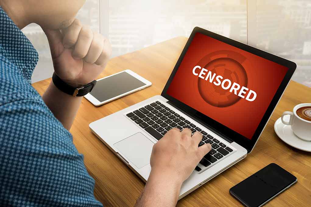 488661286 featured image Person uses laptop with "CENSORED" on screen.