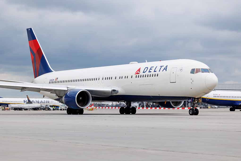 2305553471 featured image Delta Airlines airplane on airport runway, cloudy sky.