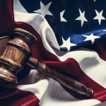 Exploring Tom Homan’s Influence on Immigration Policy and National Security Gavel resting on the American flag.