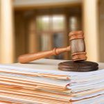 Intense Demand for Epstein Document Release Sparks Political Tensions Gavel resting on stack of paperwork in courtroom.