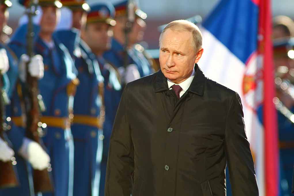 83211922 featured image A man in dark coat at a military event.
