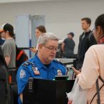 TSA agent checks passenger documents at airport security