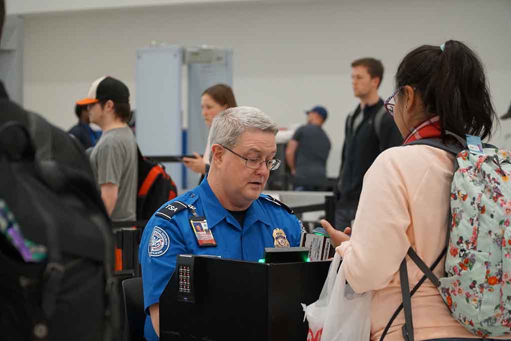 TSA agent checks passenger documents at airport security