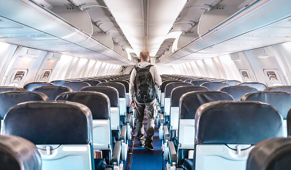 1664709973 featured image Person walking down empty airplane aisle
