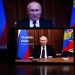 Man speaking on screen with Russian flag background