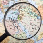 Magnifying glass focused on the Middle East map