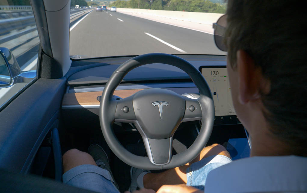 1725105379 featured image Person in Tesla car using autopilot on highway.