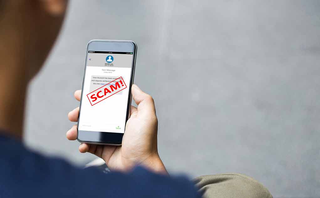2058303887 featured image Person reading a scam message on a smartphone