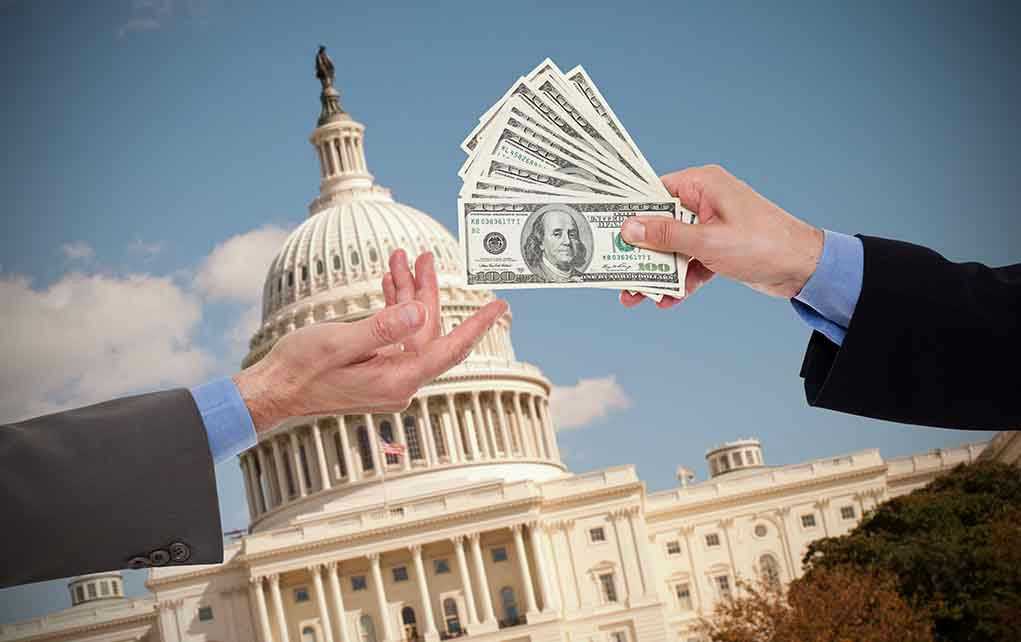 Hands exchanging money in front of Capitol building