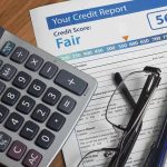 The Mystery of Credit Scores: What You Don’t Know Calculator and glasses on credit report document