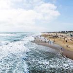 State Threat FORCES Stunning City Reversal Crowded beach with waves and people enjoying sun