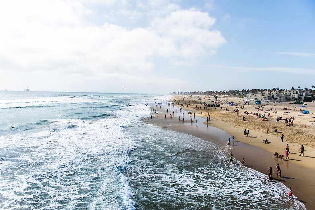 697274677 Crowded beach with waves and people enjoying sun