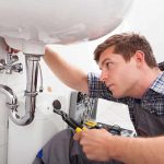 DIY Boom: 80% Embrace Fix-It Culture A plumber working under a sink with tools
