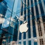 Admin BLOCKS UK Power Grab—Apple Escapes Backdoor Trap Apple store with glass facade and city reflections