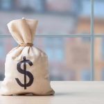 Tax-Free Growth Stalled by Common Mistake Money bag with dollar sign on table.