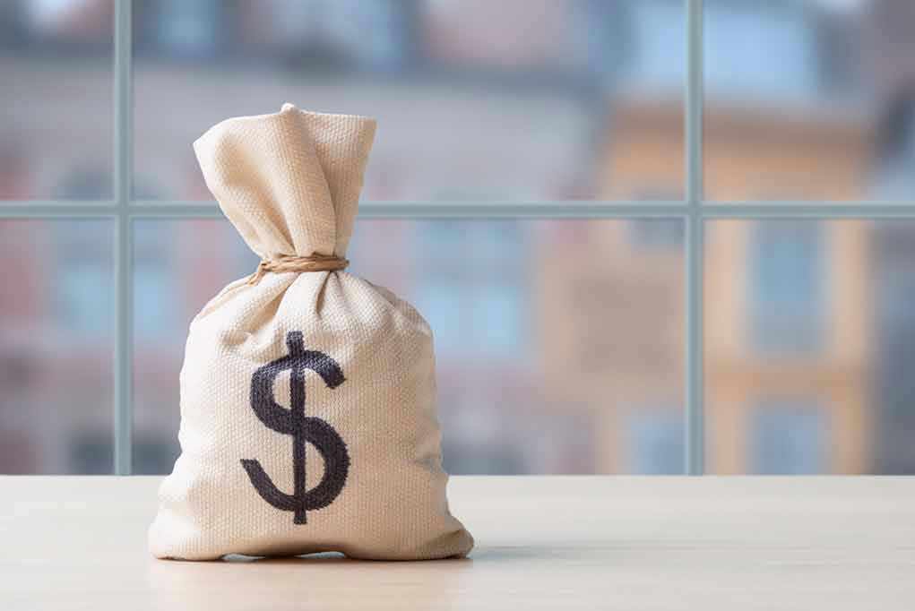 2425646037 Money bag with dollar sign on table.