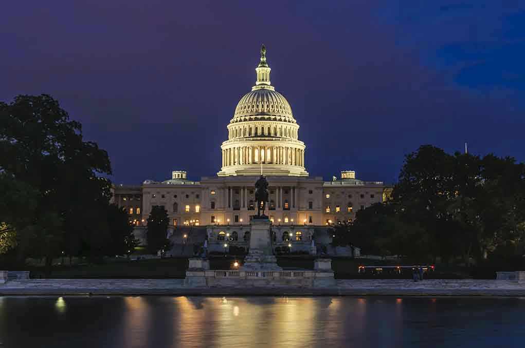 412916230 Illuminated capitol building at night with reflection in water