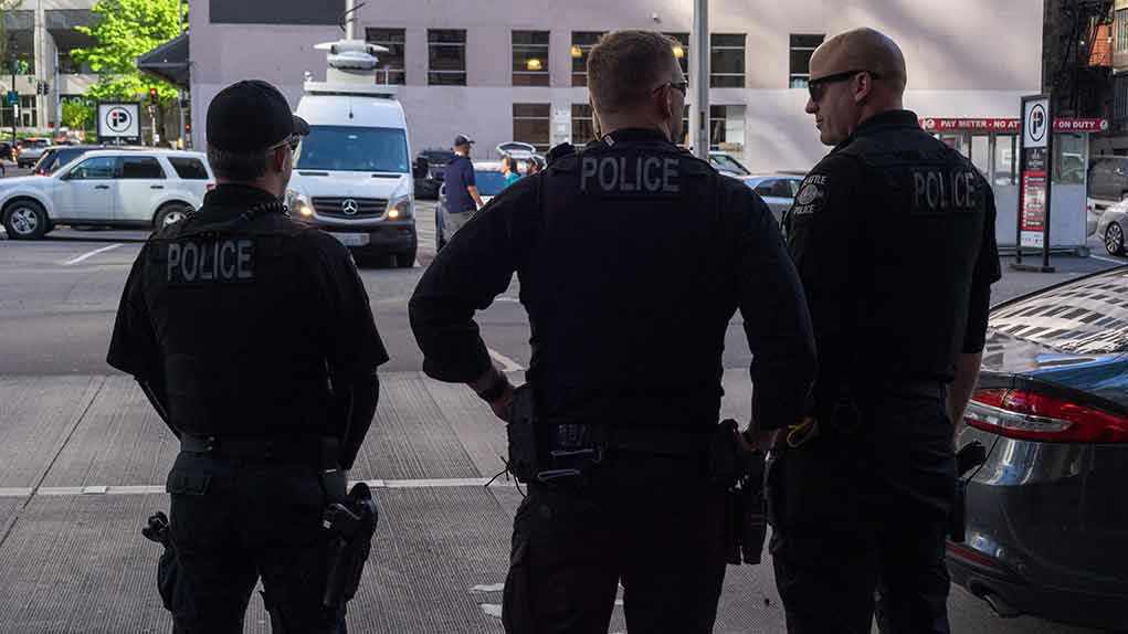 Three police officers standing on a city street