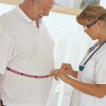 Medicine Reprograms Body—Doctors Shocked! A healthcare professional measuring a patients waist with a tape measure