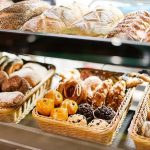 Food Engineers HIJACK Brain Circuits A display case filled with various types of baked goods including breads and pastries