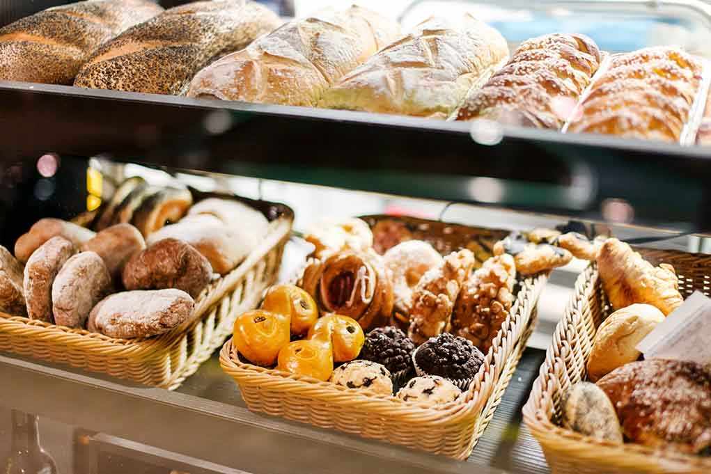 Food Engineers HIJACK Brain Circuits A display case filled with various types of baked goods including breads and pastries