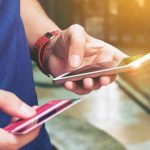 Holiday Shopping Trap—BNPL Danger Looms Person holding a smartphone and a credit card preparing for a digital transaction