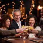 Drinking Myth SHATTERED—Daily Sip Triggers Silent Risk People laughing while clinking glasses at a bar