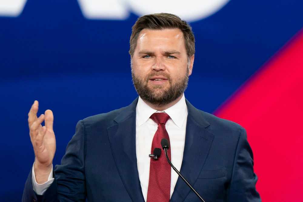 Man in a suit speaking at an event