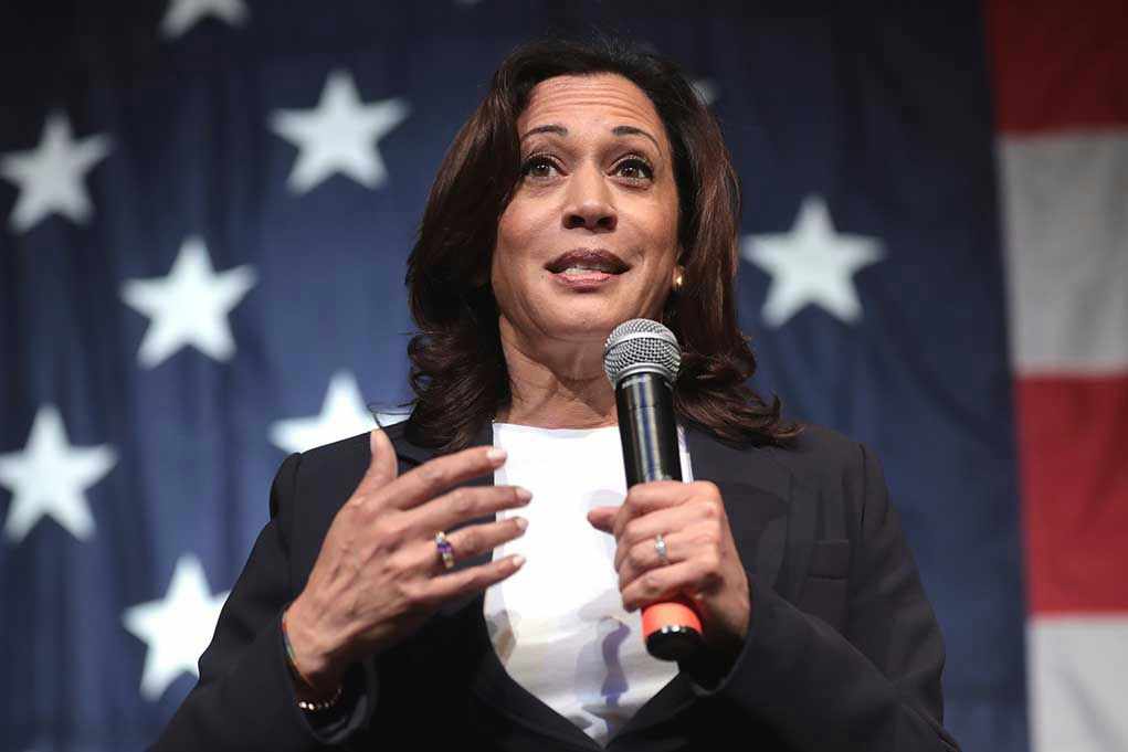 Woman speaking with microphone American flag background