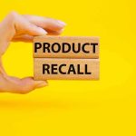 SHOCKING Contamination: Hygiene Products Pulled Hand holding Product Recall blocks on yellow background