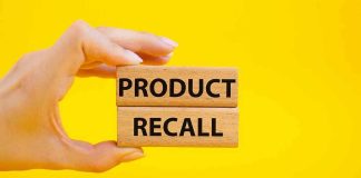Hand holding Product Recall blocks on yellow background