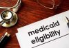 $11 Billion Medicaid SCANDAL Hits State Stethoscope pen document about Medicaid eligibility on table