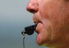 Close up of a sports coach blowing a whistle