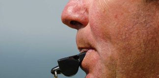 Close up of a sports coach blowing a whistle