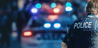 Cop KIDNAPS Woman From Mall Parking Lot Police officer with patrol car and flashing lights.