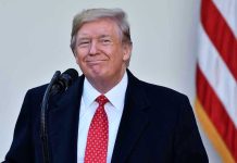 Trump’s NYC Crackdown Sparks OUTRAGE Man in suit and tie speaking at podium.