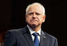 Man in suit with a U.S. flag pin.