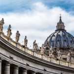 St Peters Basilica dome with statues and clouds