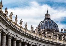 St Peters Basilica dome with statues and clouds
