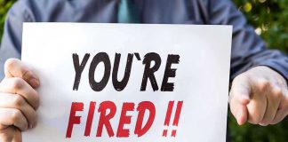 Fired and Rehired at LOWER Pay – Outrageous! Person holding YOURE FIRED sign.