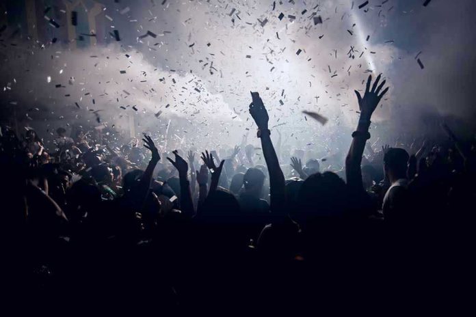 Crowd celebrating under confetti and bright lights