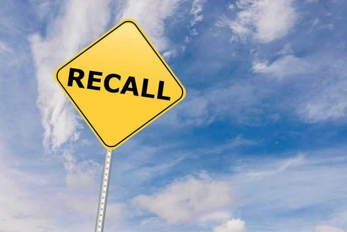 529192612 Yellow recall sign against blue cloudy sky