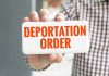 EXPEDITED Deportation: No More Delays! Hand holding sign with Deportation Order text.
