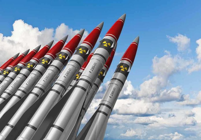 shutterstock_92717200.jpg A row of military missiles with red tips and nuclear symbols against a blue sky