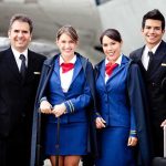 Group of airline crew members posing together at an airport